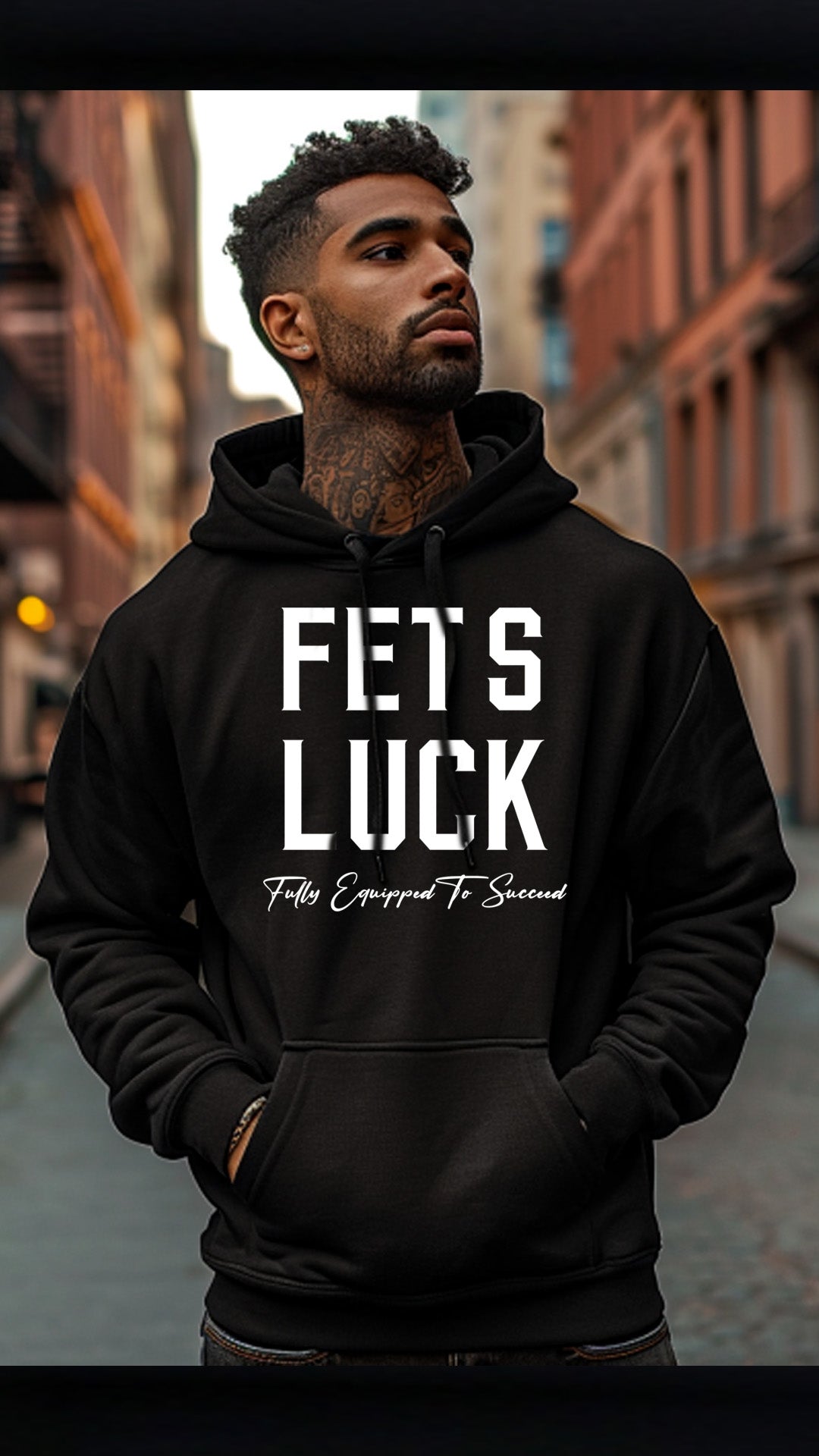 Male model wearing a black GET-ILL FET'S LUCK graphic hoodie with white front lettering in an urban streetwear setting.