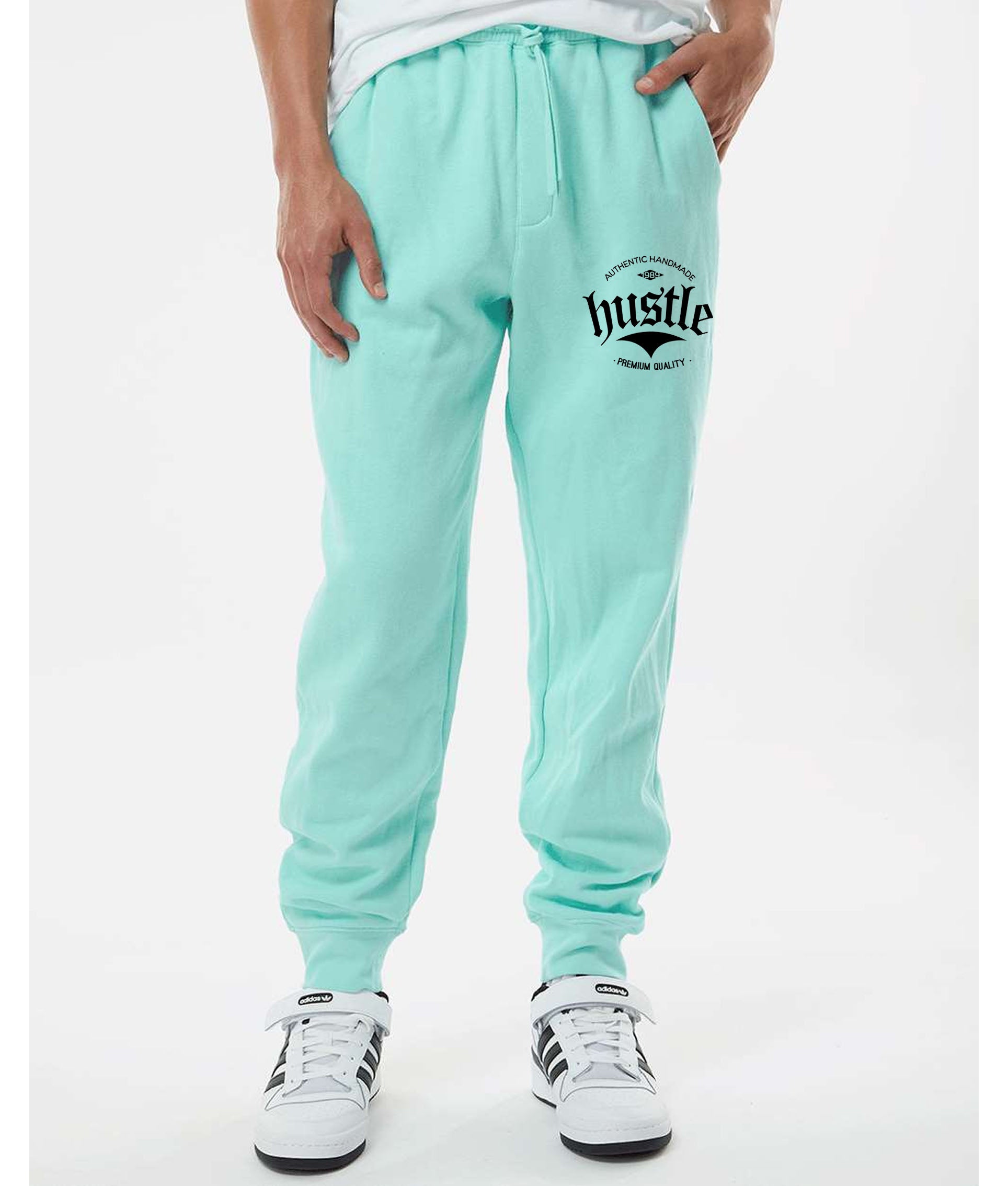 Light green "Hustle" sweatpants for sale, showing graphic detail on the leg.  "Hustle" brand light green sweatpants with a close-up of the leg graphic.