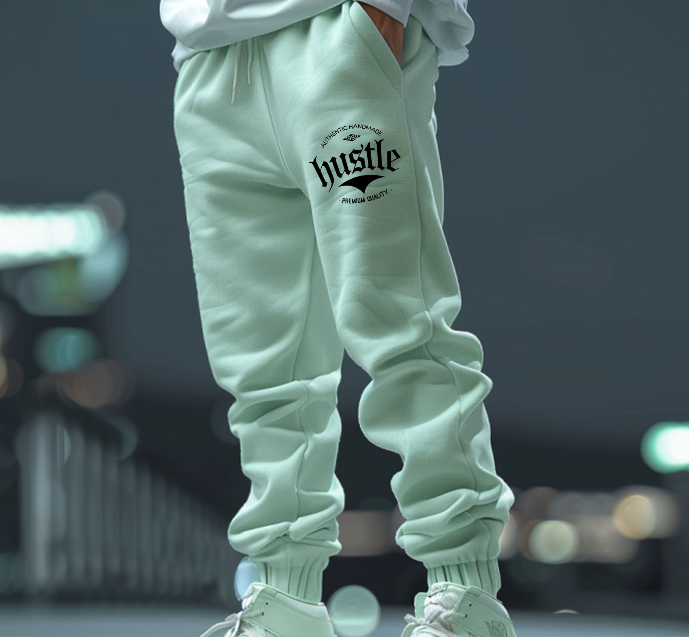 Light green "Hustle" sweatpants for sale, showing graphic detail on the leg.