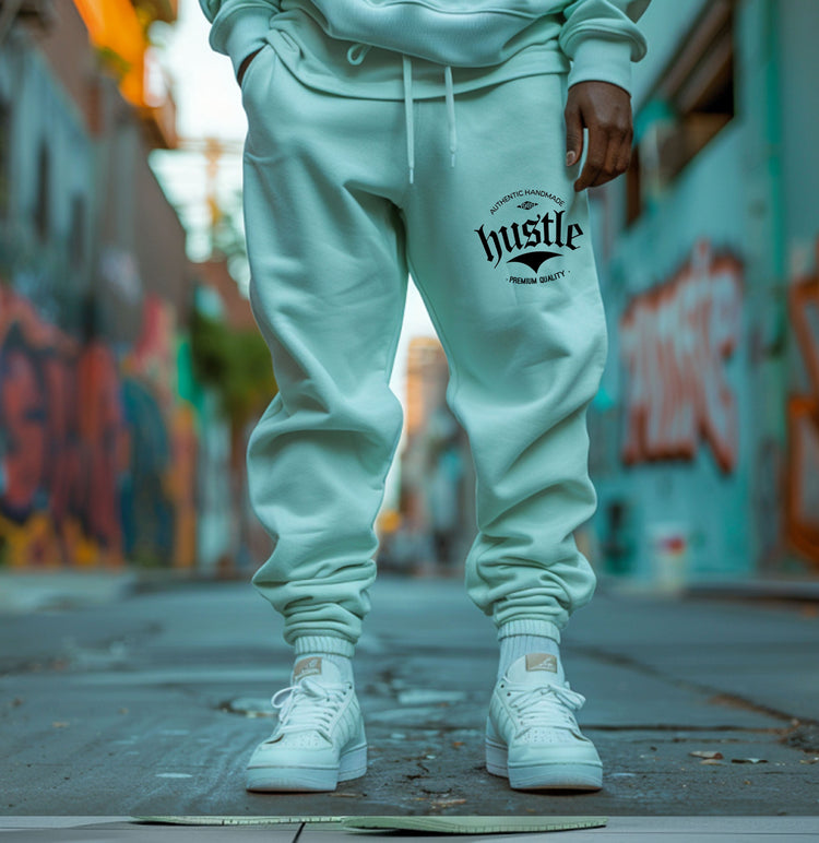 Light green "Hustle" sweatpants for sale, showing graphic detail on the leg.